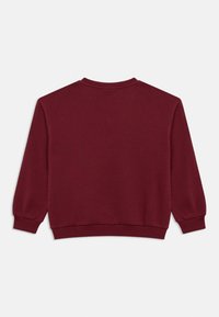 Burgundy sweatshirt med lång ärm, ribbade ärmslut och nederkant, mjuk tygtextur och rundad halsringning. Enfärgad baksida.