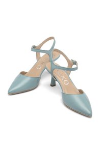 Sandali con tacco in vernice azzurro chiaro, con punta affusolata e cinturino alla caviglia. Presentano un tacco sottile e una fodera interna beige.