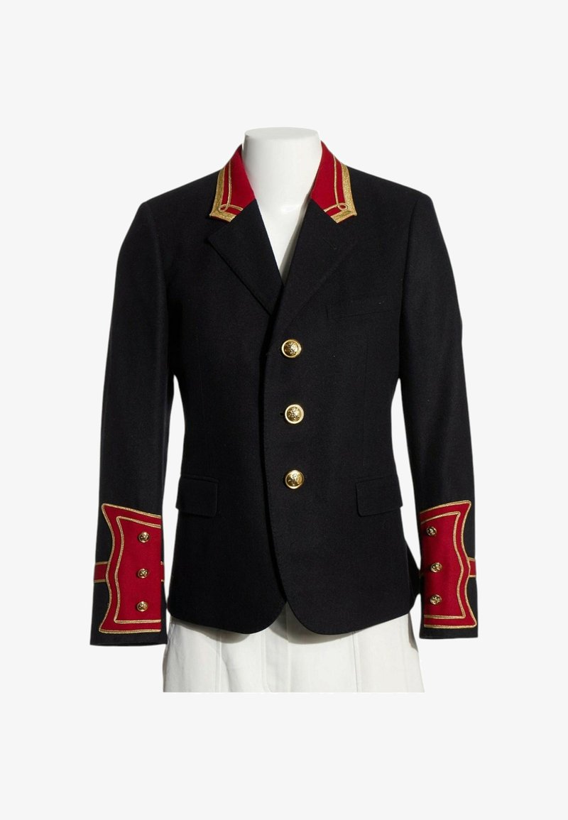 Veste noire ajustée avec des poignets et un col décoratifs rouges et dorés, ornée de trois boutons dorés sur le devant.