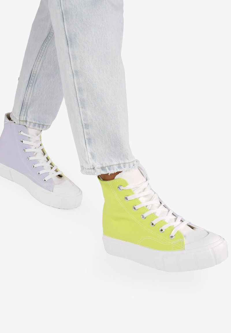 Hochgeschnittene Sneakers mit einem geteilten Design: eine Seite in helllila, die andere in kräftigem Gelb, mit weißen Schnürsenkeln und Gummisohlen.