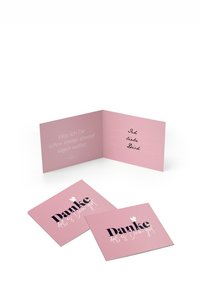 Rozā salocīta kartīte ar melnu tekstu, kas saka "Danke," ar baltām akcents. Iekšpusē rokrakstā rakstīts melnā krāsā: "Ich liebe Dich."