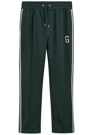 Pantalones de chándal verde oscuro con cinturilla ajustable, bolsillos laterales, franjas laterales blancas y un logo "G" crema en el muslo izquierdo.