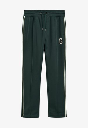 Tmavě zelené tepláky s elastickým pasem na šňůrku, postranními kapsami, bílými bočními pruhy a krémovým logem "G" na levé stehně.