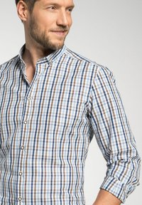 Herenoverhemd met een geruit patroon in blauw, bruin en wit. Klassieke kraag, knoopsluiting aan de voorkant en opgerolde mouwen. Van katoen.