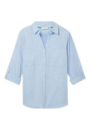 Camicia azzurra chiara a maniche lunghe realizzata in un tessuto testurizzato. Presenta due tasche sul petto e maniche arrotolabili fissate con bottoni. Design con chiusura frontale a bottoni.