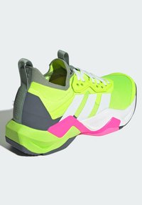 Neon gele sportieve schoen met witte en roze accentueringen, voorzien van een textuur bovenwerk, een gevoerde zool en een gewatteerde kraag. Ontworpen voor training.