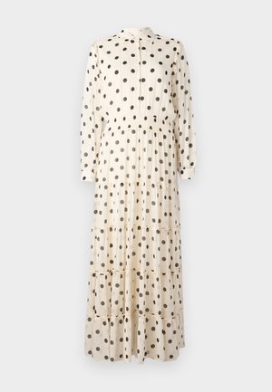 Robe longue de couleur crème en tissu léger, présentant des pois noirs, un devant boutonné, un col et une conception à volants.