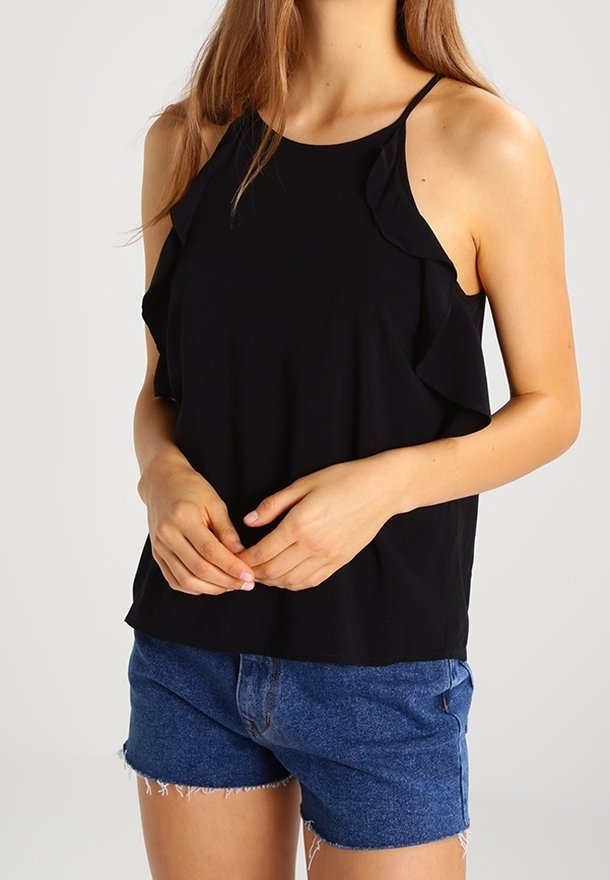 Černý bezrukávový top s volánkovými detaily kolem výstřihu, spárovaný s roztrhanými džínovými šortkami. Kola výstřih a měkká textura látky.