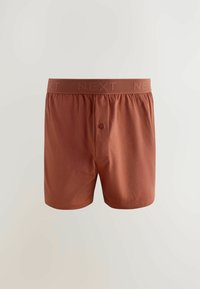 Rozsdabarna boxeralsó, puha anyagból készült, gombos záródással és közepes magasságú, "NEXT" feliratos rugalmas derékpánttal.