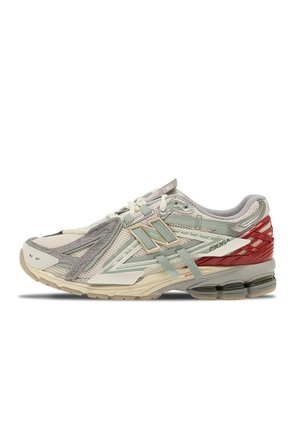 Chaussure de course avec des panneaux en mesh et en suède blanc, gris et rouge, semelle beige et détails de logo latéraux, vue de profil extérieur.