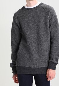 Szary, teksturowany sweter z okrągłym dekoltem i rękawami raglanowymi, z prążkowanymi mankietami i dołem. Ciepły materiał o miękkim wykończeniu.
