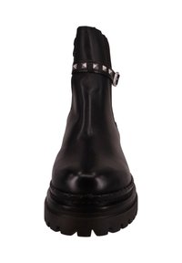 Czarny skórzany botek za kostkę z okrągłym noskiem, fakturowaną powierzchnią, paskiem ozdobionym ćwiekami i masywną podeszwą. Z ozdobą w postaci srebrnej klamry.