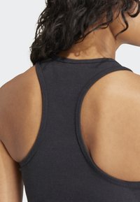 Mørk grå atletisk tanktop med en tettsittende design, brede armhull og en glatt, elastisk tekstur. Har scoop-neck og racerback-stil.