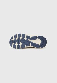 Semelle de chaussure avec un design texturé ; présente une base en caoutchouc bleu et une semelle intermédiaire couleur crème avec des motifs de traction circulaires et rectangulaires.