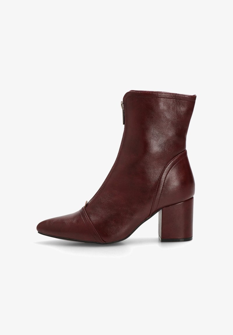 Botín de piel burdeos hasta el tobillo con punta afilada y tacón cuadrado. Presenta un cierre lateral con cremallera y una textura suave, con detalles de costura.