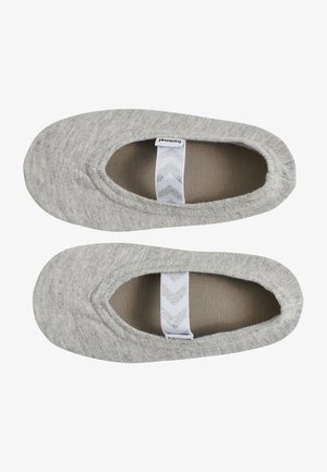 Chaussons en tissu gris avec une forme arrondie, texture douce, ouverture élastiquée et une étiquette blanche à motif en zigzag à l'intérieur.