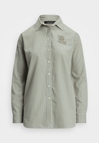 Csíkos, visszafogott zöld és fehér gombos ing, amelynek az gallérja, hosszú ujjai és hímzett logója van a mellrészén. Simaságot sugalló pamut anyag.