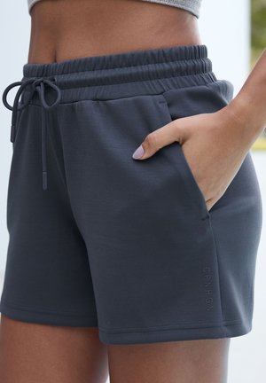 Pantaloni corti in cotone grigio con cintura elastica e cordino. Dotati di una tasca laterale e un logo stampato sull'orlo. Tessuto morbido.
