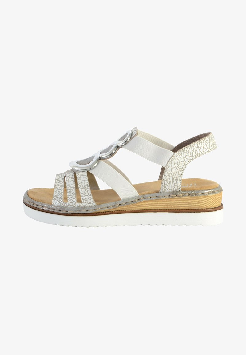 Sandale blanche avec un dessus texturé, des accents métalliques décoratifs, des brides élastiques et une semelle compensée avec un aspect bois et une semelle en caoutchouc.
