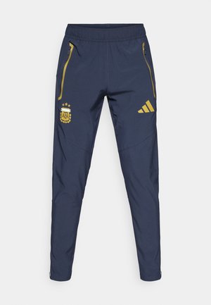 Tamnoplave sportske hlače s elastičnim pojasom, bočnim džepovima na patentni zatvarač, zlatnim detaljima i izvezenim logotipom Argentinskog nogometnog saveza.