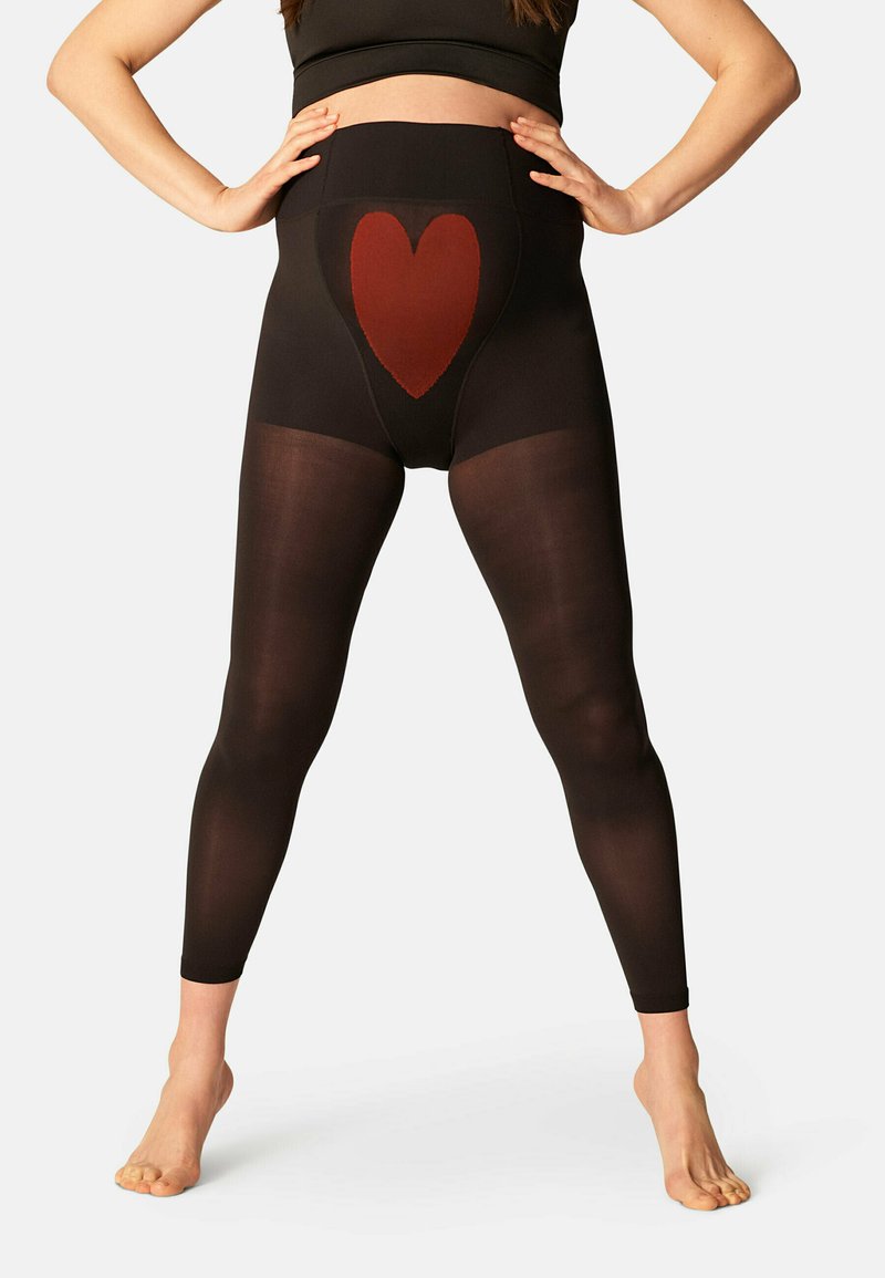 Zwarte leggings met een hoge taille en een rood hartpatroon aan de voorkant. Doorzichtige stof van taille tot enkel, gladde textuur.