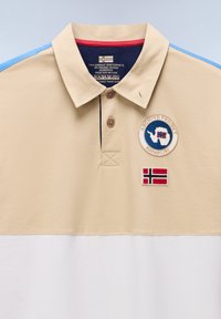 Beżowo-biała koszulka polo z niebieskimi paskami na ramionach, dwoma brązowymi guzikami i dwoma naszywkami z mapami oraz norweskimi flagami na piersi.