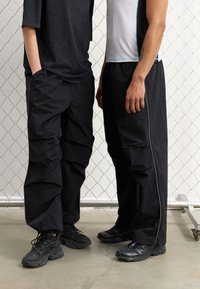 YOURTURN by Zalando UNISEX - Donji dijelovi trenirke - black