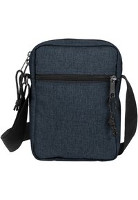 Sac bandoulière en tissu bleu foncé, de forme rectangulaire, avec une poche zippée à l'avant, une sangle réglable, et un matériau texturé avec un motif subtil.
