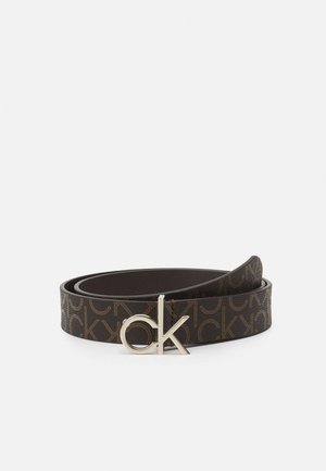 Ciemnobrązowy pasek z powtarzającym się wzorem "ck" i srebrną klamrą z logo "ck", zwinięty na białym tle.