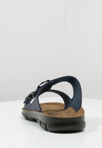 Navy blue sandal with an open back, adjustable buckle, and a cushioned cork footbed; rubber sole provides flexibility and grip.