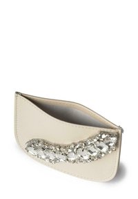 Clutch in pelle crema con un elegante arrangement di gemme trasparenti su un lato. Texture liscia con forma curvata e chiusura a zip.