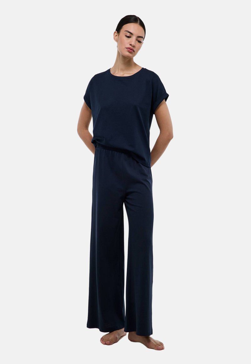 Ensemble de détente bleu marine comprenant un haut à manches courtes avec poignets roulés et un pantalon à jambes larges. Fabriqué en tissu doux et respirant avec une coupe décontractée.
