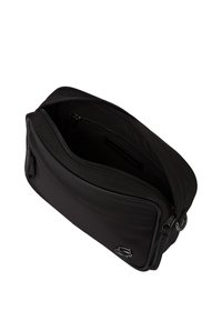 Borsa a tracolla rettangolare nera con tasca frontale con zip e scomparto principale con zip aperto, che mostra l'interno nero e il dettaglio del logo argentato.