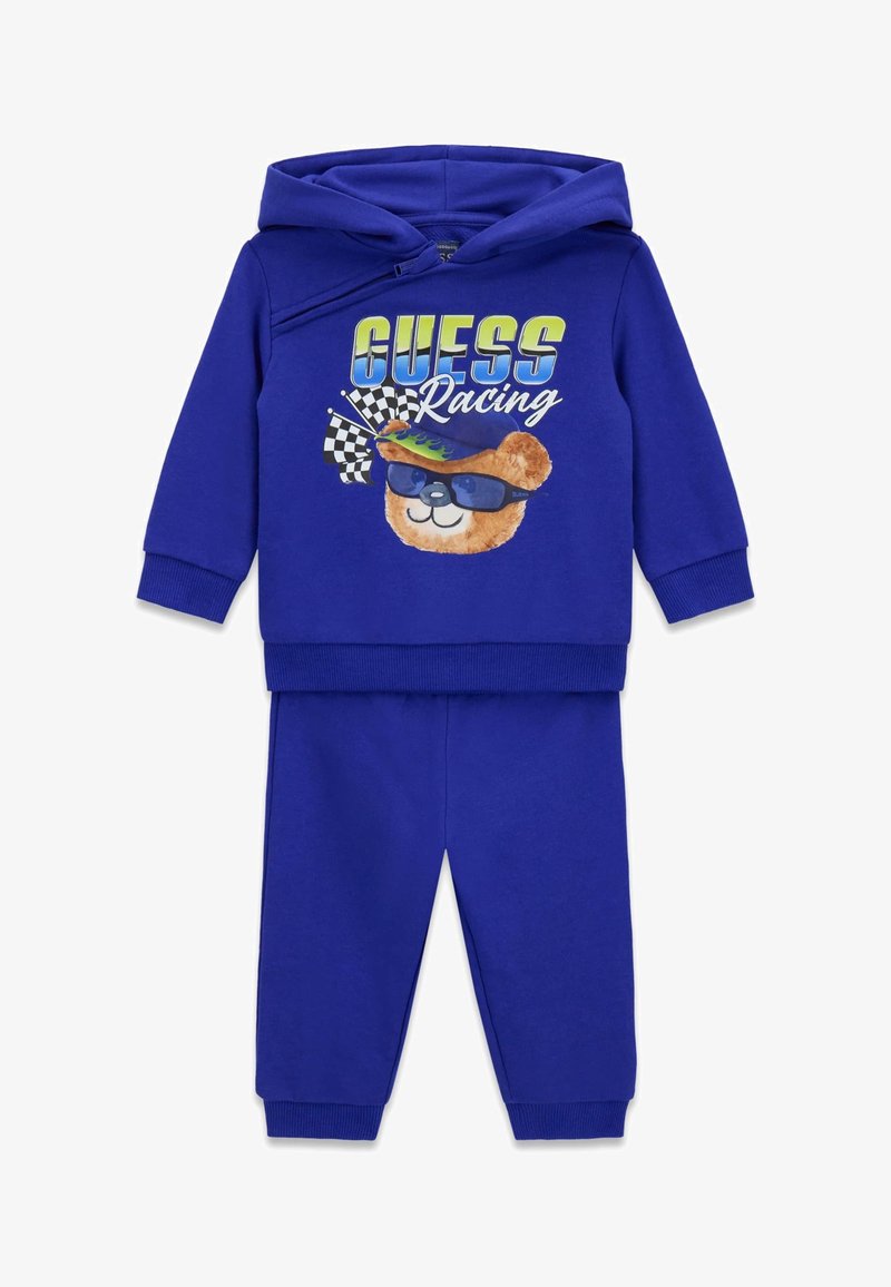 Blauw katoenen trainingspak met een hooded sweatshirt met een berenafbeelding, zonnebril en racevlaggen; gecombineerd met bijpassende broek.