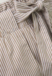 Tissu rayé beige et blanc avec une finition texturée, comportant un détail de nœud à la taille et un élastique froncé.