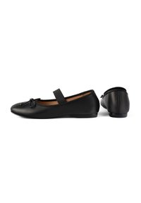 Chaussures plates Mary Jane noires avec bouts arrondis, détail nœud sur le devant, bride élastique et finition en cuir lisse, vues de côté et de dos.