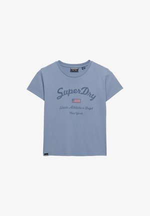 T-shirt bleu clair à col rond avec l'inscription "SuperDry", un drapeau américain et le texte "State Athletics Dept New York" sur le devant.