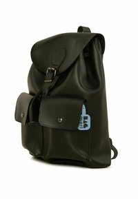 Sac à dos en cuir noir avec un rabat arrondi, deux poches avant, quincaillerie argentée et une étiquette bleue. Texture lisse avec un design minimaliste.