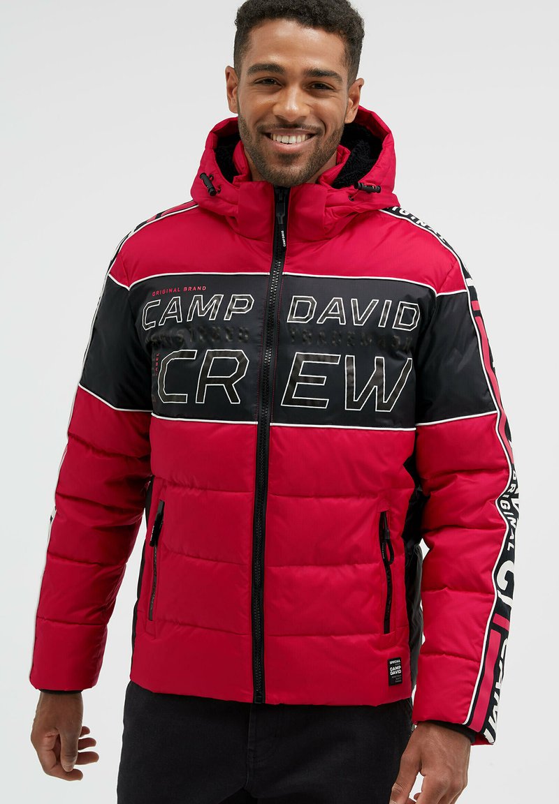 Rot und schwarze gepolsterte Jacke mit Kapuze, Reißverschluss, großem "CAMP DAVID CREW"-Schriftzug und seitlichen Taschen mit Reißverschlüssen.