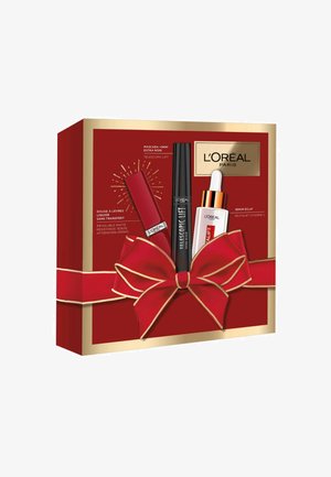 Boîte-cadeau rouge avec des accents dorés et un grand nœud rouge, contenant des produits de maquillage L'Oréal Paris : mascara, rouge à lèvres liquide et sérum.