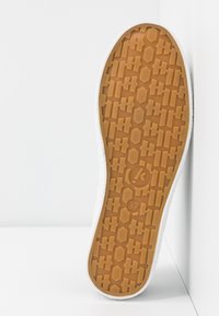 Schuhsohle aus strukturiertem Gummi, mit hexagonalem Muster und einem weißen Rand. Größe mit 37 gekennzeichnet.