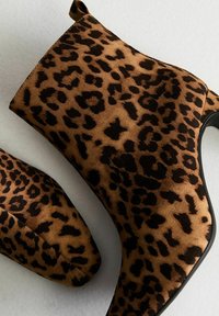 Botas de tobillo con estampado de leopardo, hechas de suave ante, con punta afilada y suela negra elegante. Incluyen una lengüeta para ponerlas y quitarlas fácilmente.