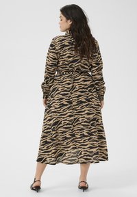 Maxi-jurk in een bruin en zwart tijgerstreeppatroon, lange mouwen, taille met strik en een gespleten zoom, gemaakt van lichtgewicht, gestructureerde stof.