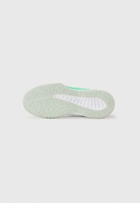 Sole of a shoe featuring a light green rubber base, textured pattern for grip, with white accents and a smooth side surface.