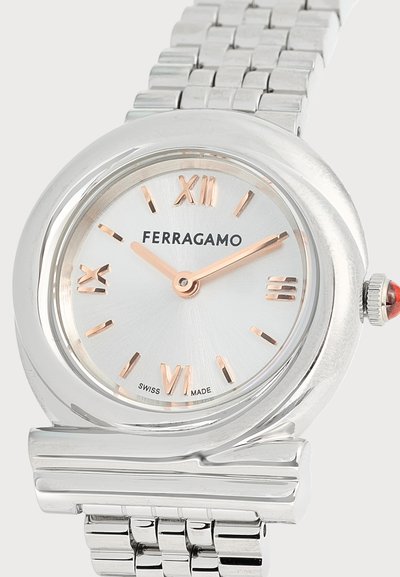 Ασημένιο ρολόι Ferragamo με στρογγυλό καντράν, ρωμαϊκούς αριθμούς σε ροζ χρυσό, κατασκευασμένο στην Ελβετία, με μεταλλικό μπρασελέ.