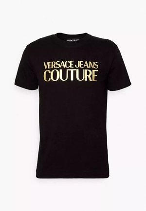 T-shirt di cotone nera con grande scritta dorata "VERSACE JEANS COUTURE" sul davanti. Maniche corte e scollatura a girocollo. Texture liscia.