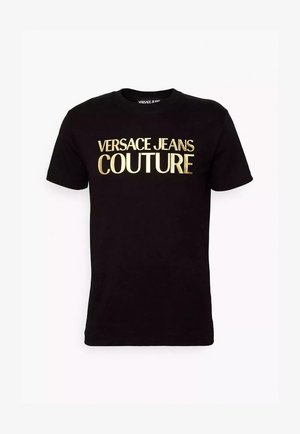 T-shirt di cotone nera con grande scritta dorata "VERSACE JEANS COUTURE" sul davanti. Maniche corte e scollatura a girocollo. Texture liscia.