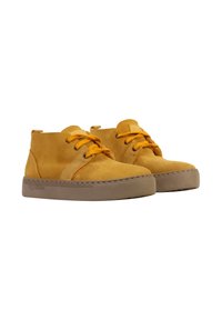 Bottines en suède jaunes, à bout rond, avec un design à double œillet, des lacets jaunes et une semelle en caoutchouc beige avec un détail de couture.