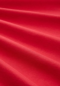 Tela roja con una textura suave, que presenta pliegues suaves y un color uniforme, adecuada para diversas aplicaciones textiles.