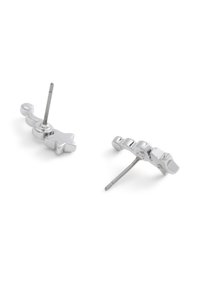 Boucles d'oreilles en métal argenté avec un design étoile et vague, présentant une surface lisse et un système d'attache à tige droite pour un maintien sécurisé.